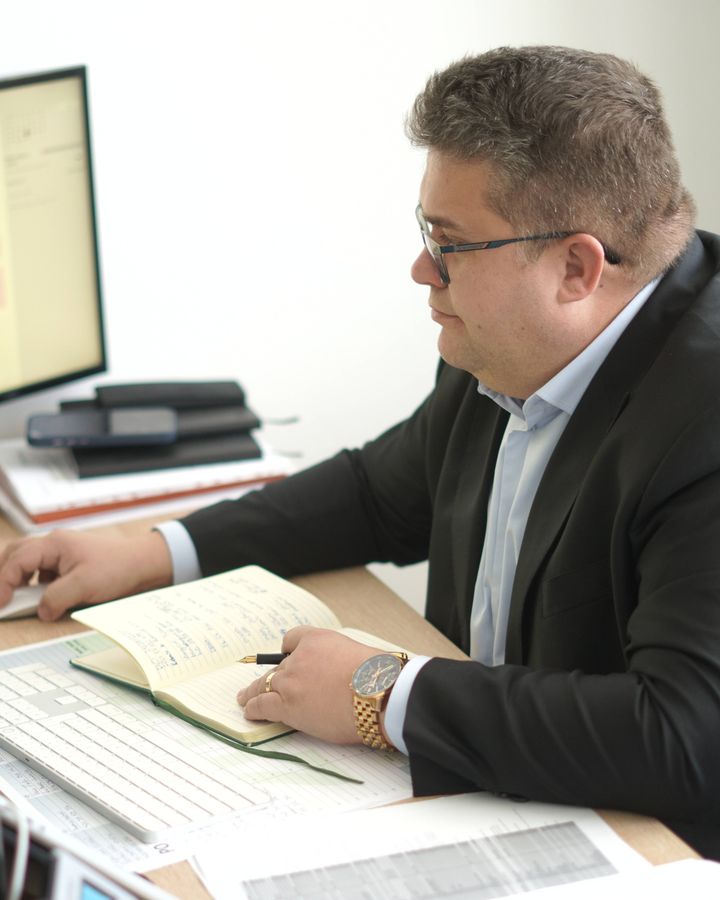 Michal Kais pri práci s dokladmi za stolom